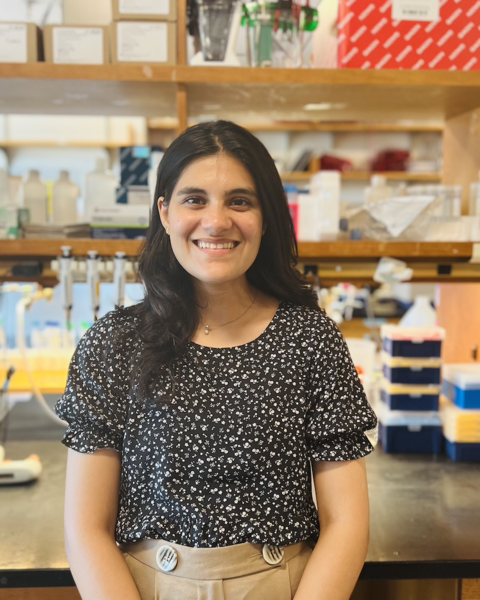 Smiling woman with long brown hair in a science lab